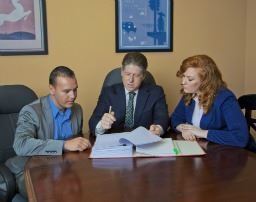 two people sign a cohabitation agreement with a lawyer
